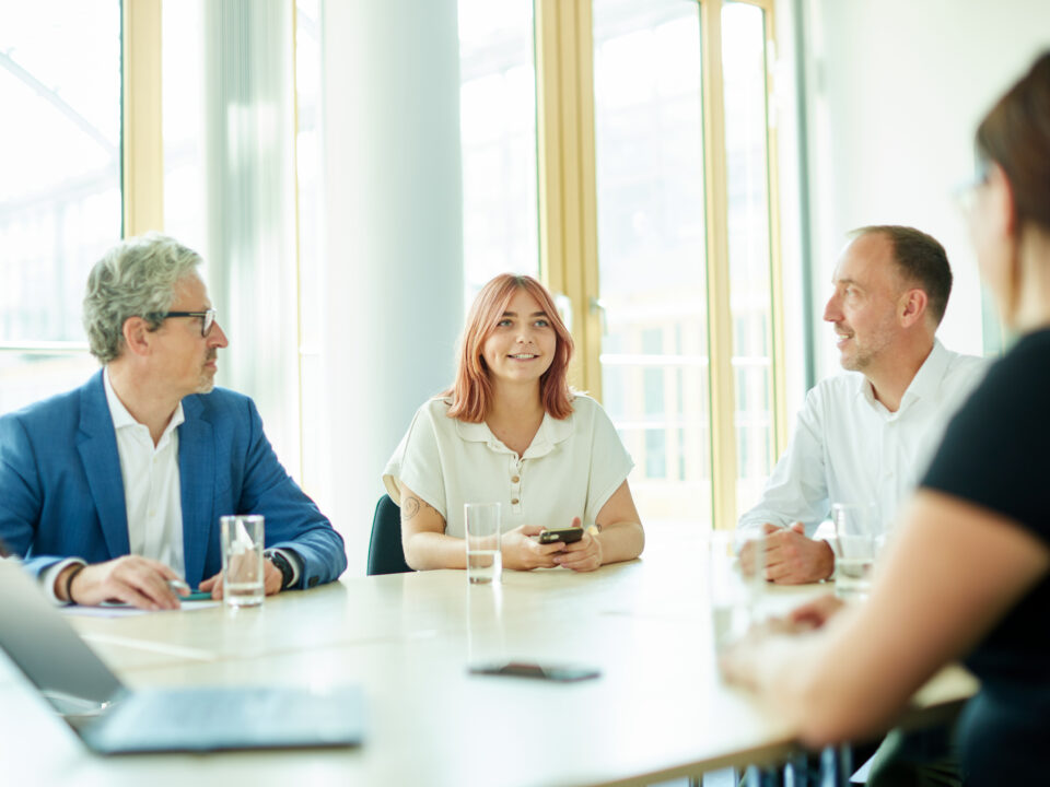 Vier Mitarbeitende am Tisch